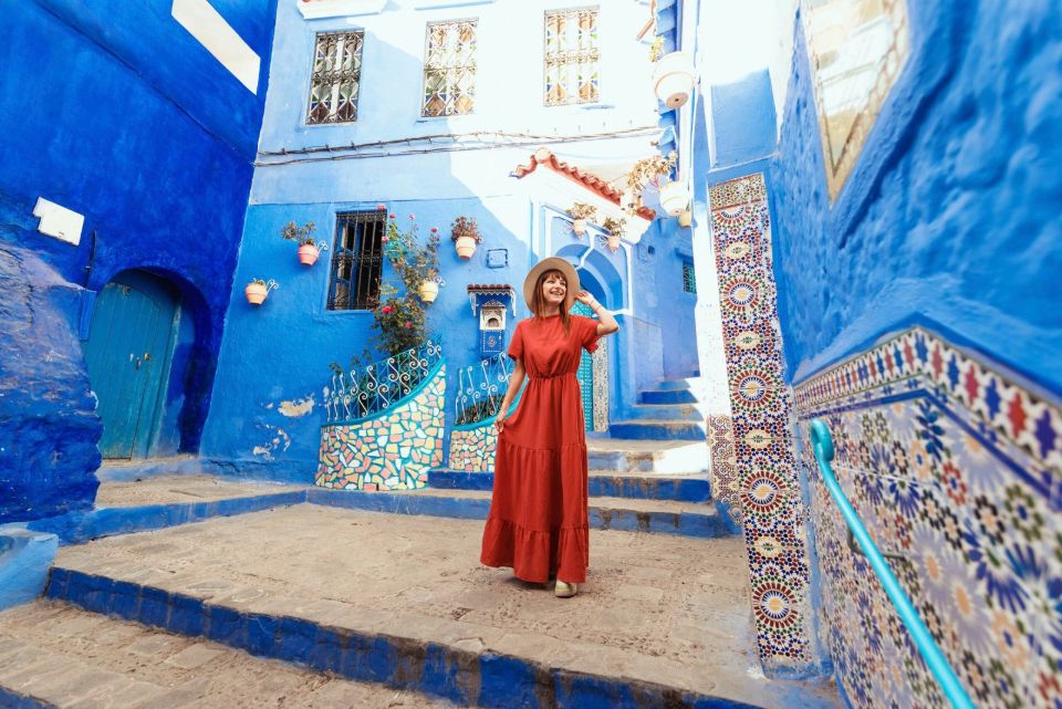 Young woman with red dress visiting the blue city chrfchaouen Morocco