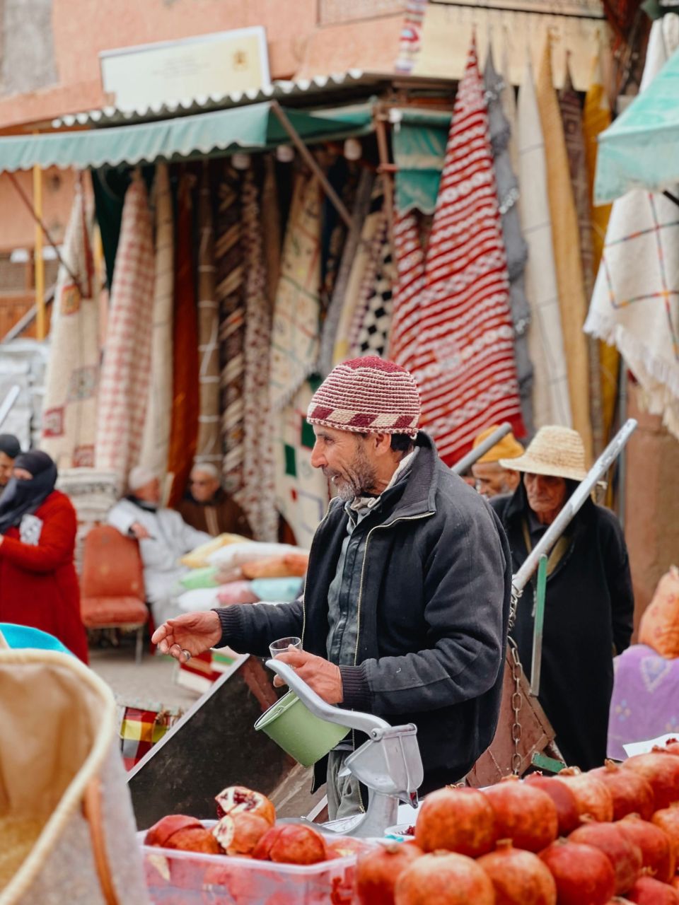 Street vendor selling fresh pomegranate juice in a Moroccan souk, a small purchase paid in cash