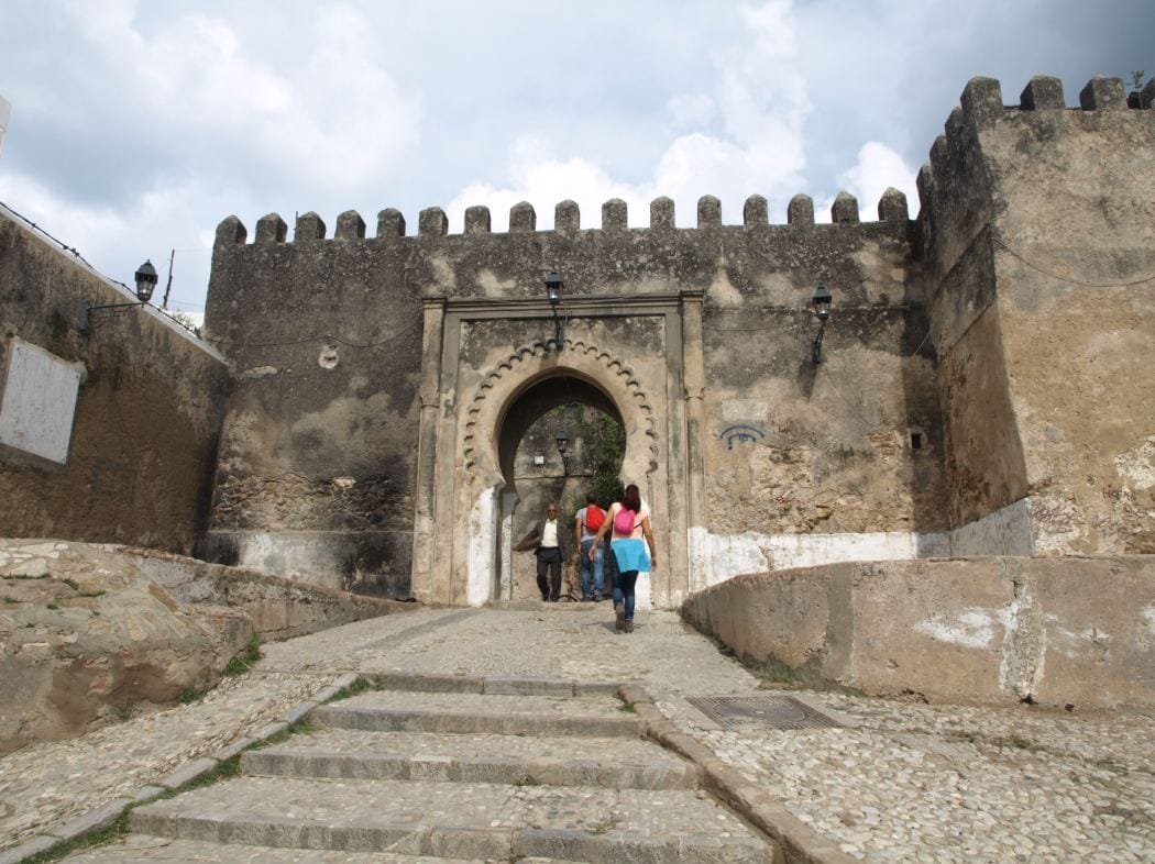 Visitors entering a historic gate in Tangier Kasbah during a Morocco tour