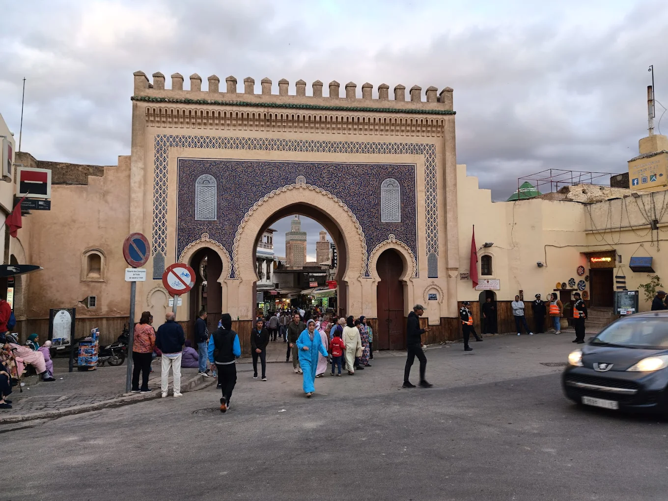 Bab Bou Jeloud gate in Fes, Morocco, with visitors entering the historic medina through traditional Moroccan architecture.