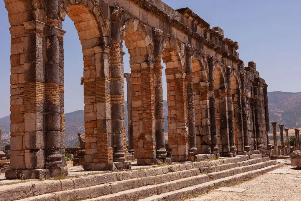 Ancient Roman columns and arches at the Volubilis ruins near Meknes, Morocco.