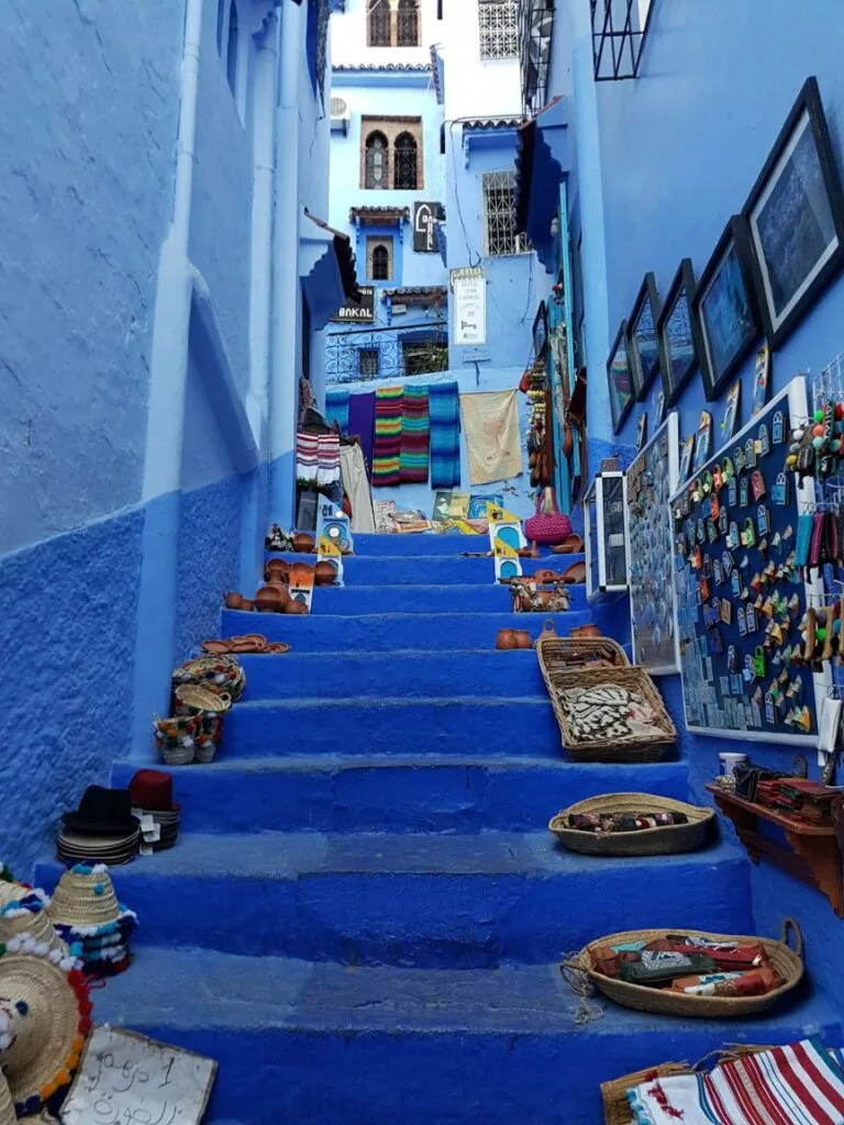 Narrow winding streets and whitewashed buildings painted in vivid shades of blue in the medina of Chefchaouen, a iconic mountain town nestled in the Rif Mountains of northern Morocco.