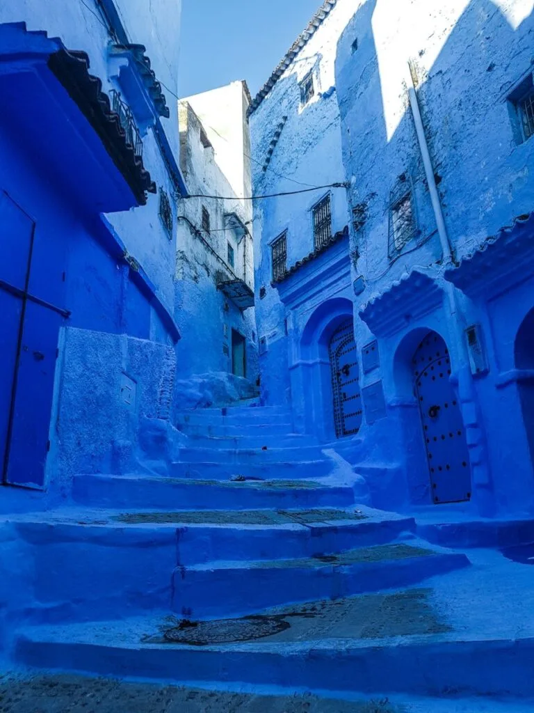 Narrow blue street in Chefchaouen medina with traditional Moroccan architecture