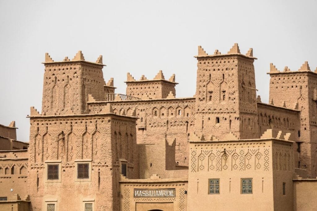 Historic mud-brick kasbah in Ouarzazate, Morocco, surrounded by traditional desert architecture.
