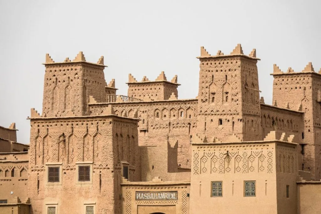 Historic mud-brick kasbah in Ouarzazate, Morocco, surrounded by traditional desert architecture.