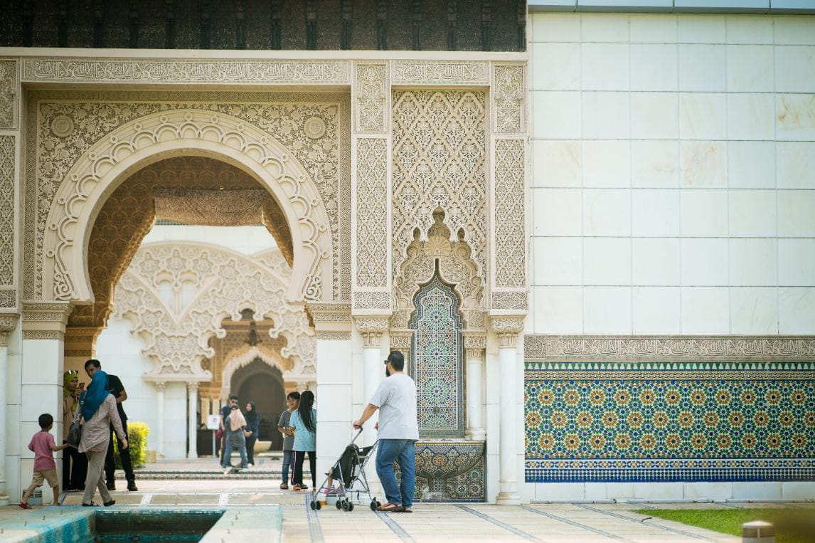 Visitors exploring a traditional Moroccan Islamic building with detailed architectural design